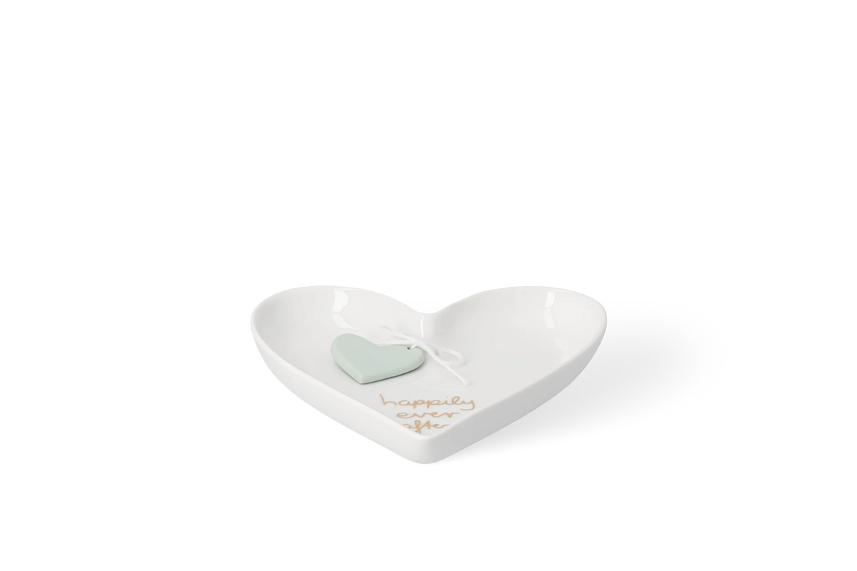 Weiße glänzende Porzellanschale in Herzform mit goldfarbenem Schriftzug, happily ever after, und hellgrünem Herzanhänger in der Vorderansicht.