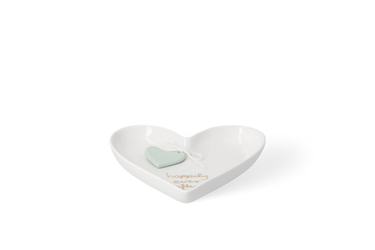 Weiße glänzende Porzellanschale in Herzform mit goldfarbenem Schriftzug, happily ever after, und hellgrünem Herzanhänger in der Vorderansicht.